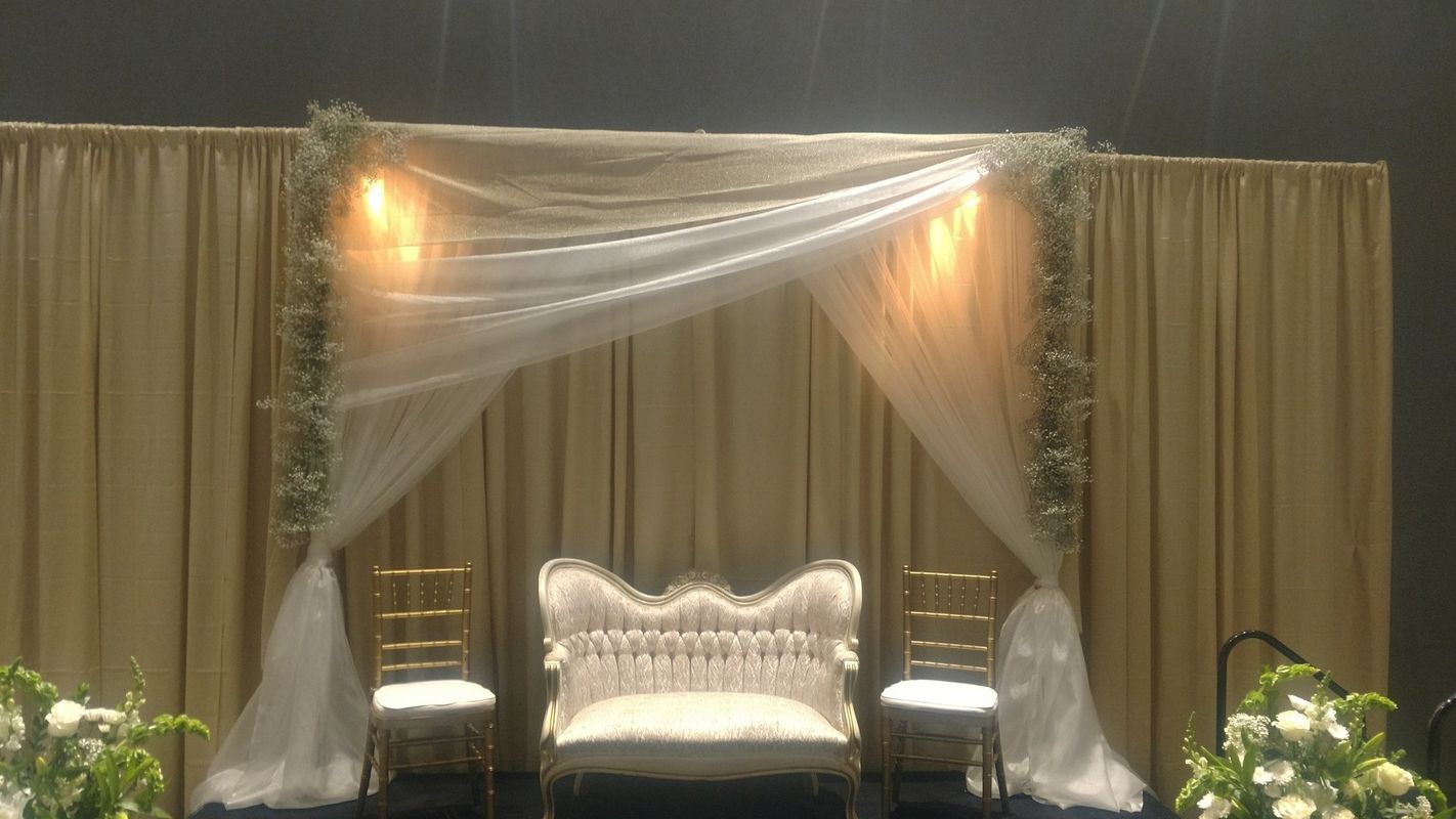 A wedding stage with a couch and chairs and a canopy