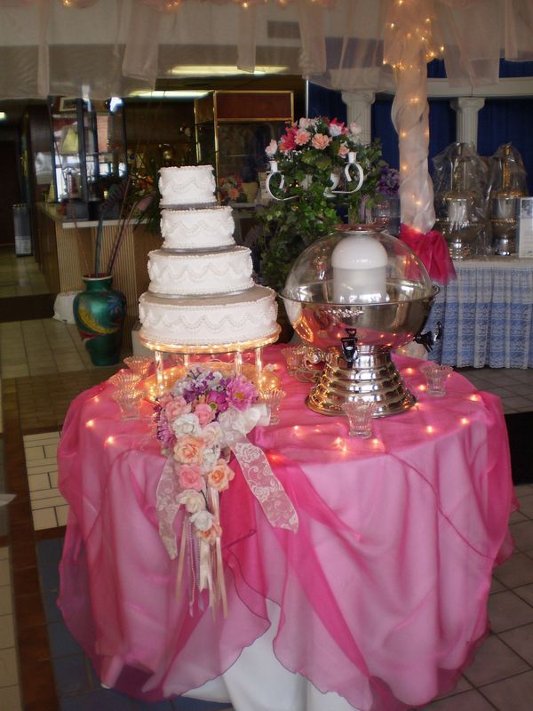 A wedding cake on a table with a pink table cloth