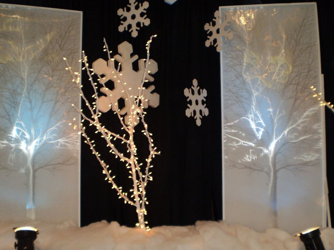 A stage with trees and snowflakes on it