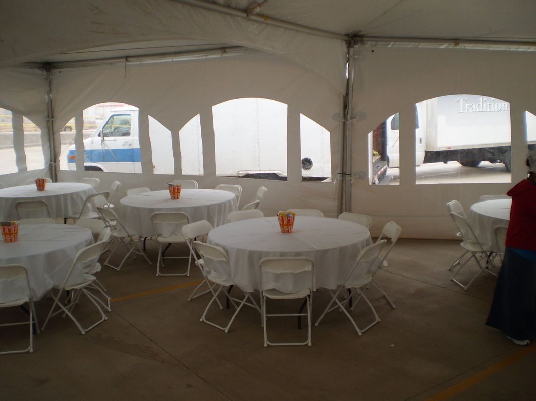 Tables and chairs under a tent with a truck in the background