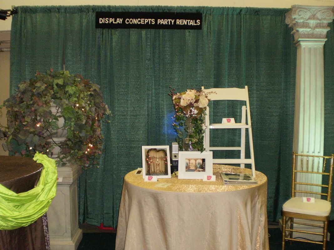 A table with flowers and a sign that says display concepts party rentals