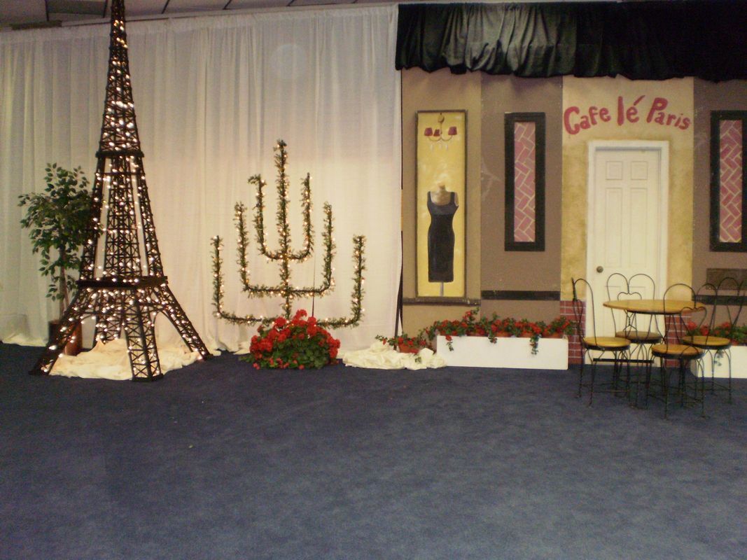 An eiffel tower is in front of a cafe le paris sign