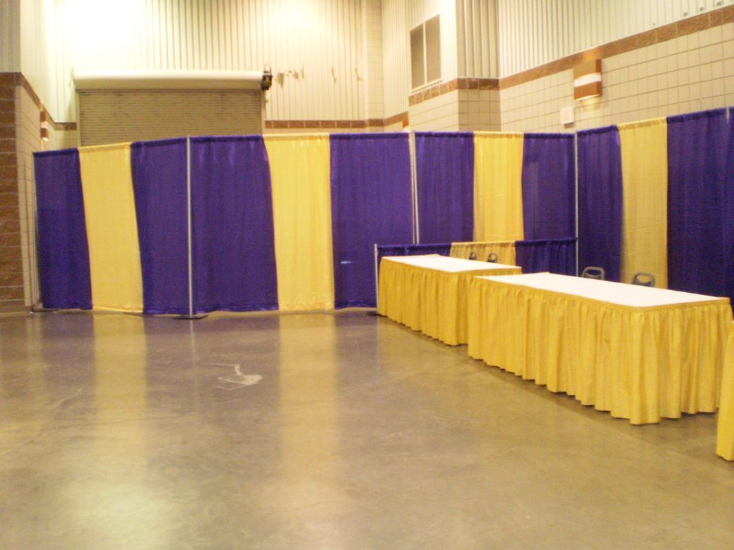 A room with purple and yellow curtains and tables
