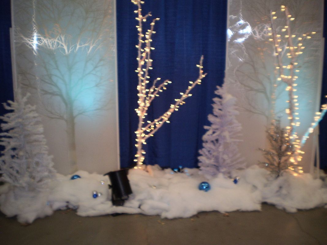 A blue and white striped curtain with trees and lights in front of it