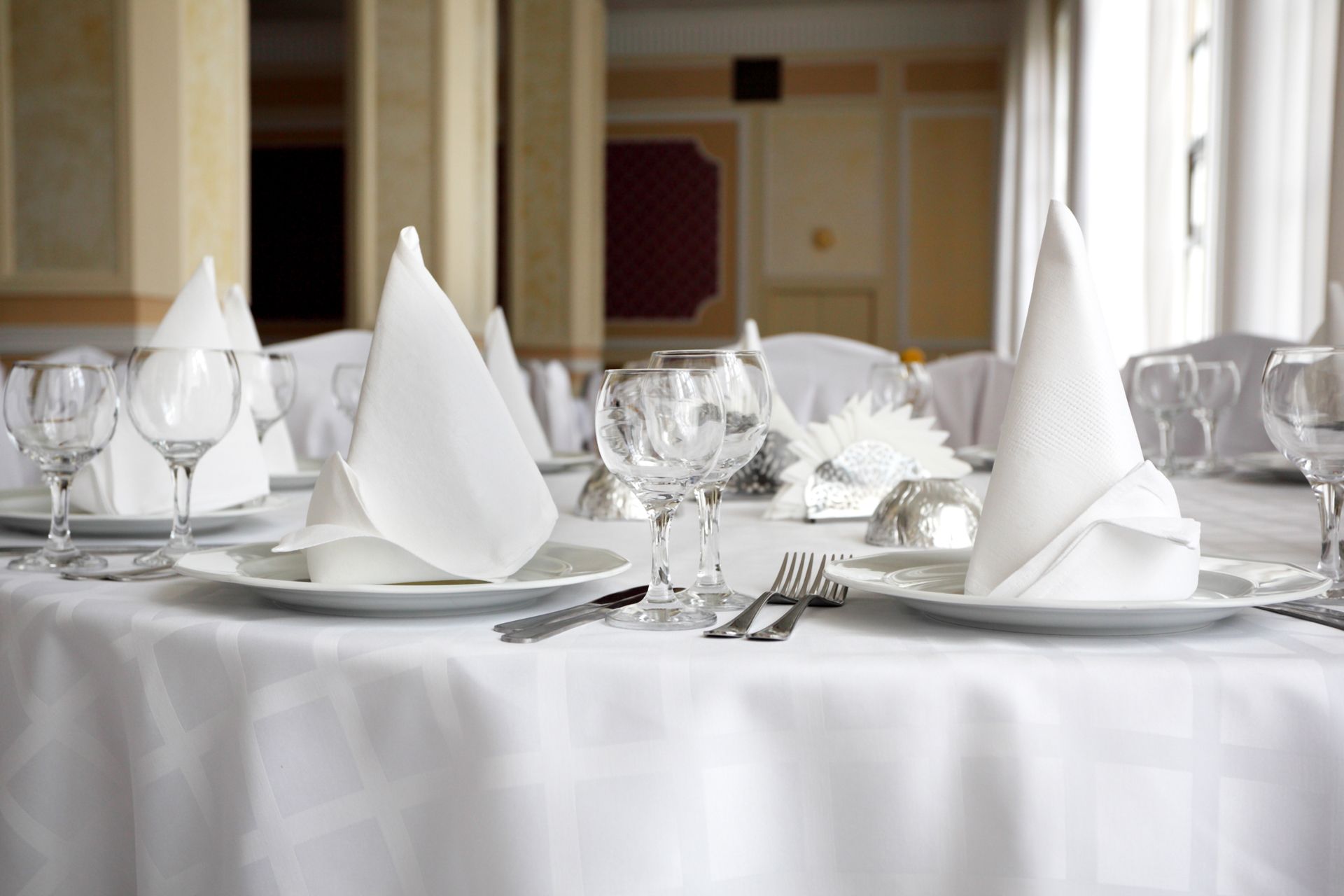 A table with plates , glasses , napkins and silverware on it