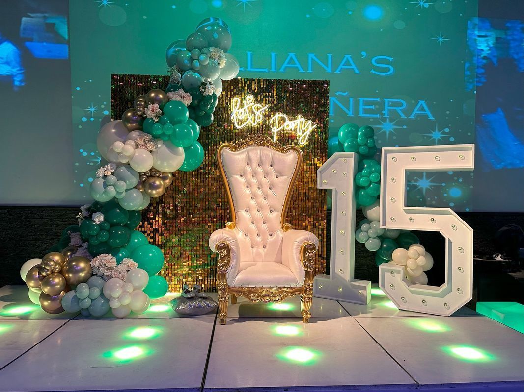 Party backdrop with a throne, balloons, a lit-up 
