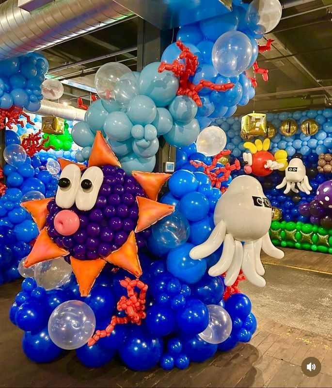 Underwater-themed balloon sculpture: a sunfish, octopus, coral, and various blue balloon clusters.