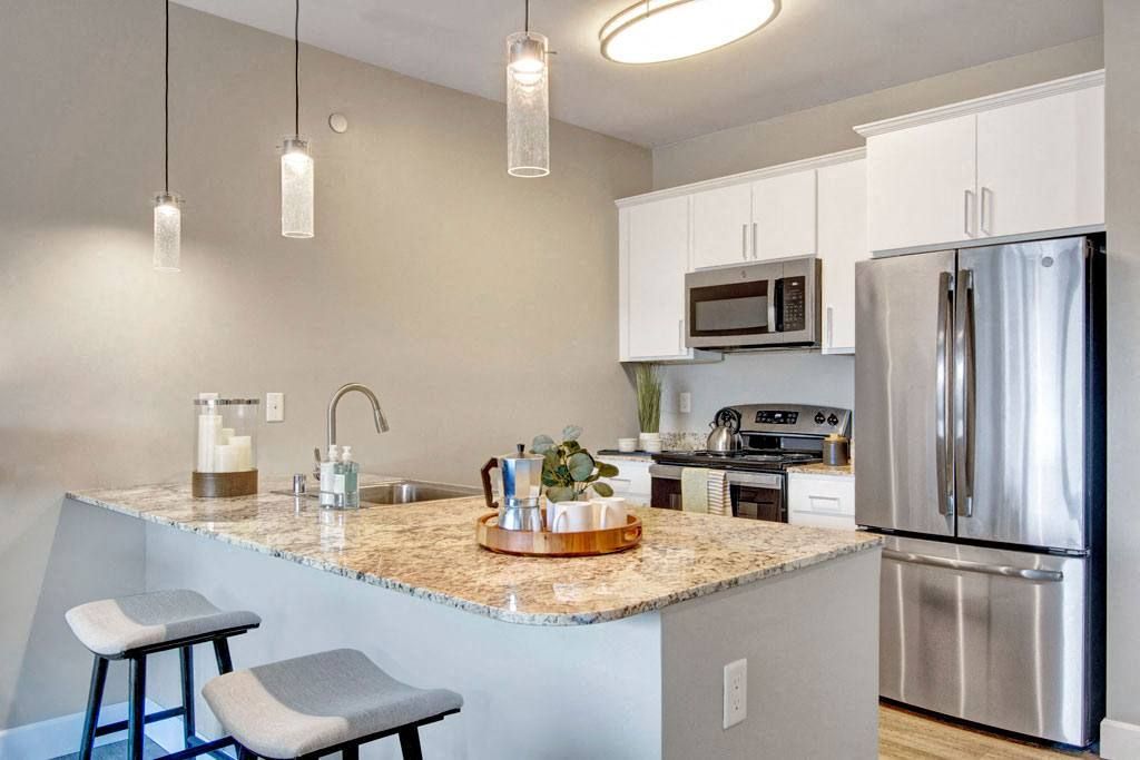 A kitchen with stainless steel appliances and granite counter tops.
