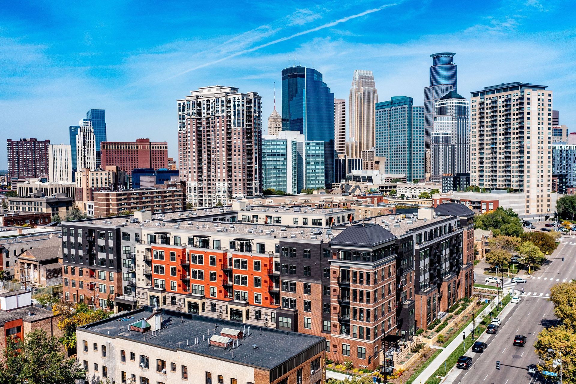 An aerial view of a city skyline with a large apartment building in the foreground.