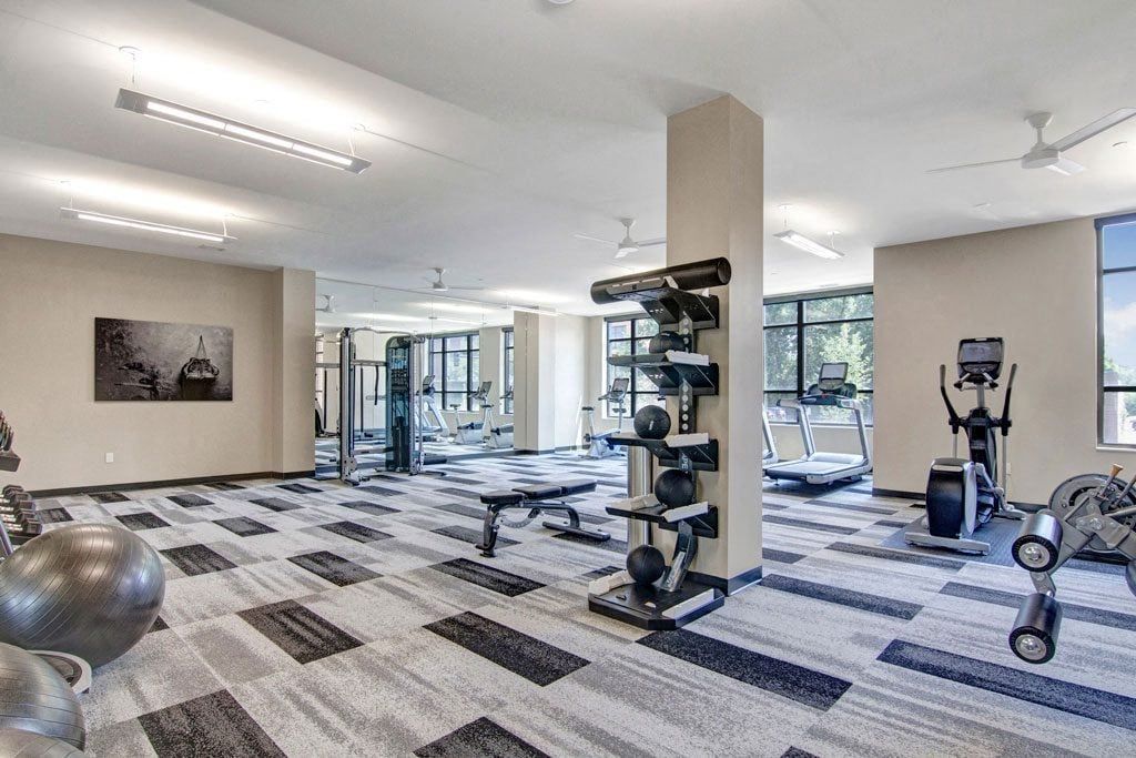 A large gym with a lot of equipment and a lot of windows.