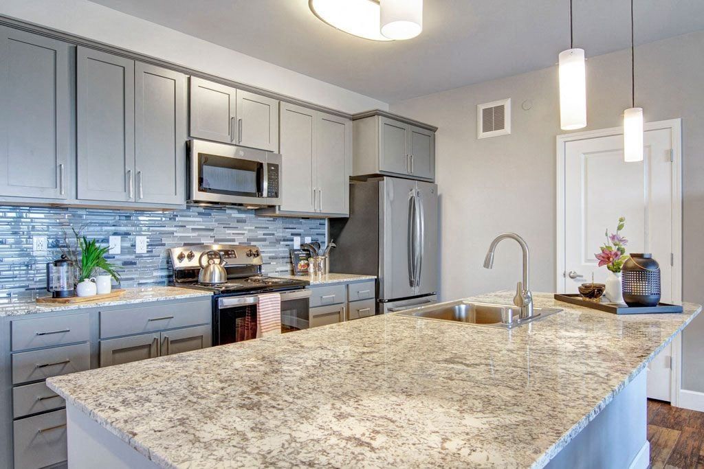 A kitchen with granite counter tops and stainless steel appliances.