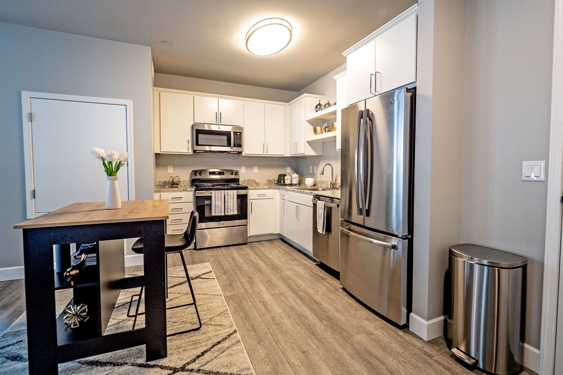 A kitchen with stainless steel appliances and a wooden table.