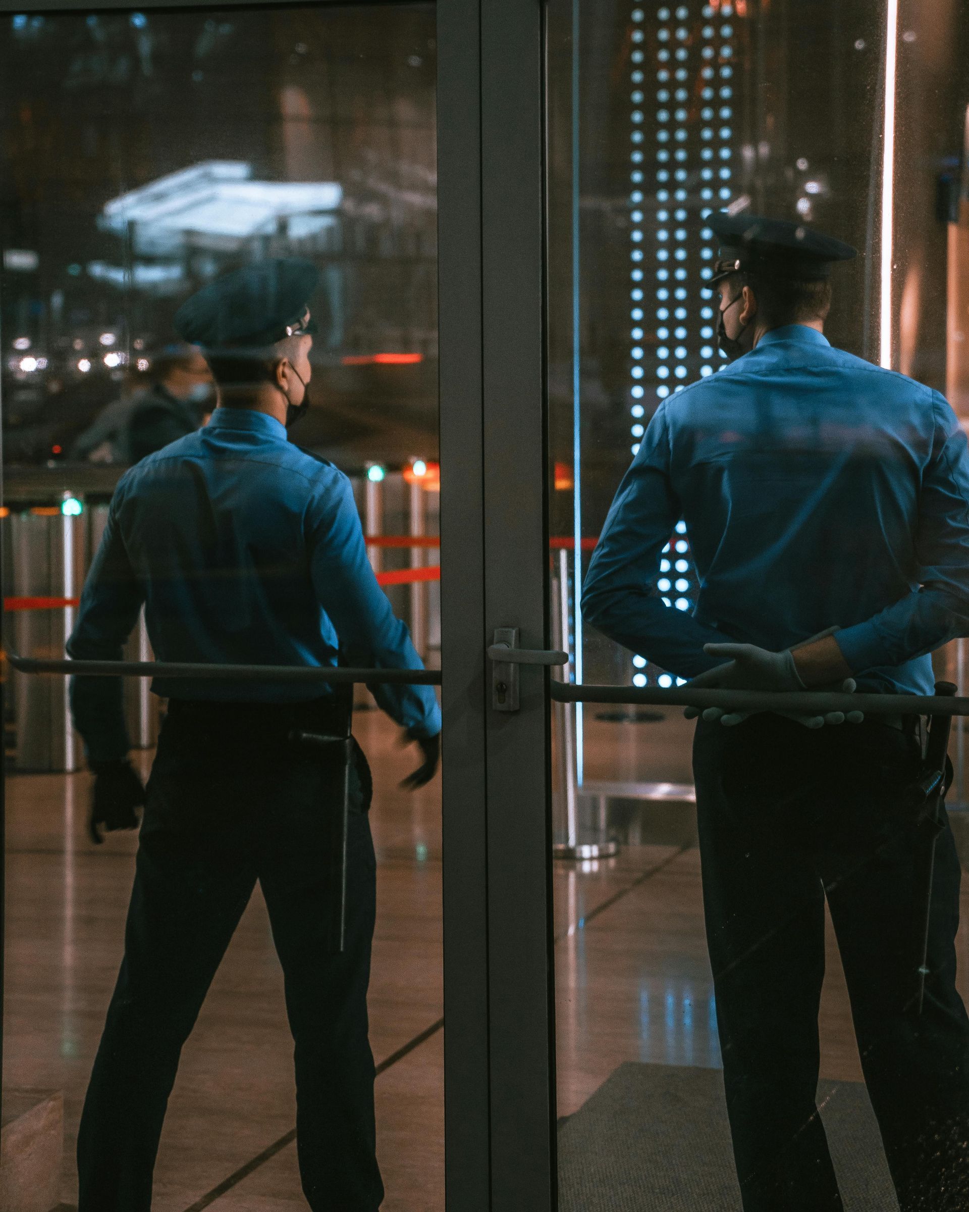 Two police officers standing in front of a glass door.