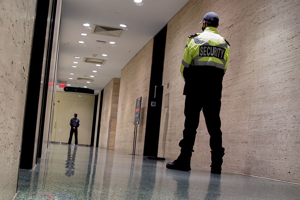 A security guard is standing in a hallway in a building