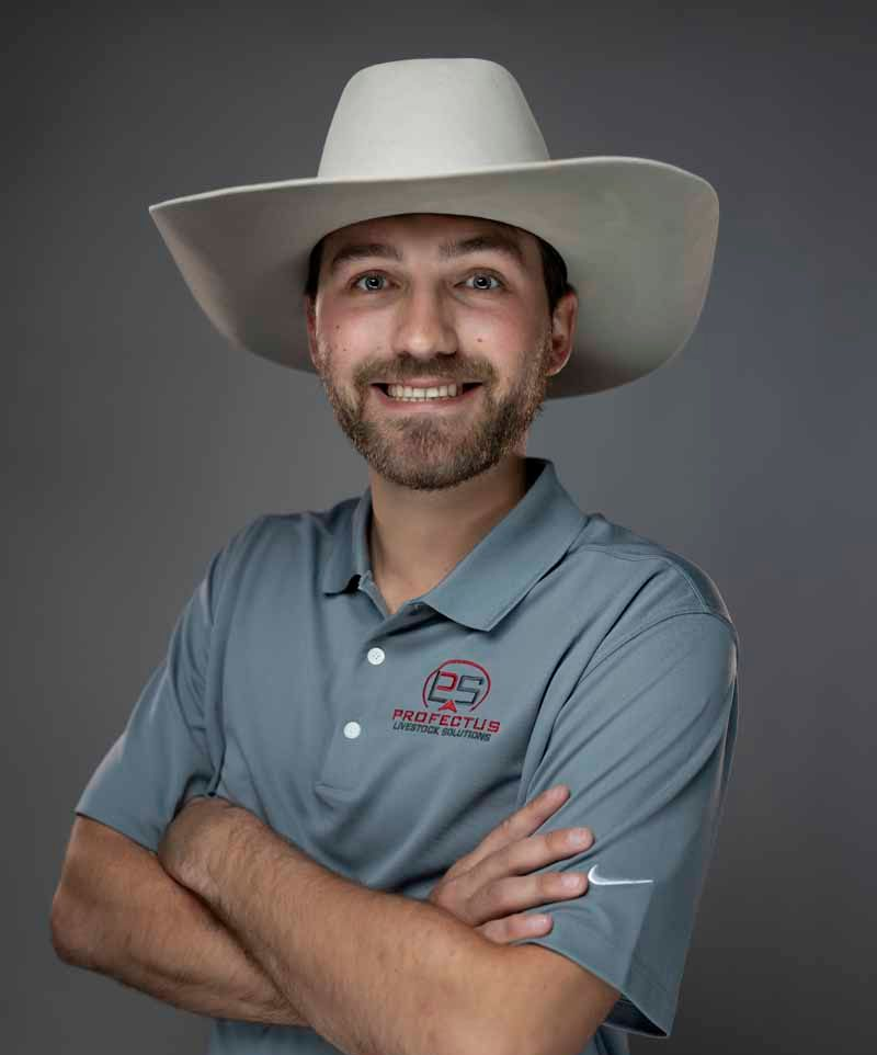 Man wearing a cowboy hat and grey polo shirt with arms crossed, smiling.