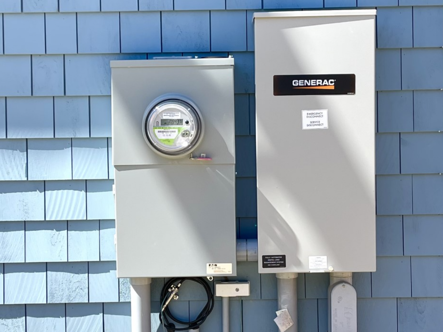 Two gray utility meters mounted on a blue shingled wall, one labeled CentralHudson