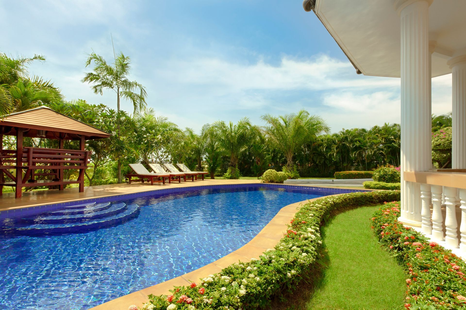 A large swimming pool with a gazebo in the background