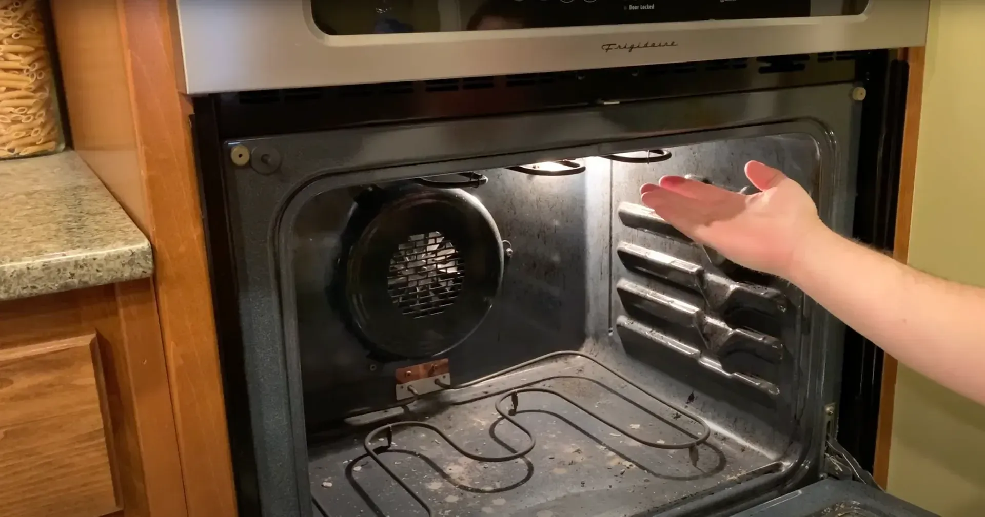 Interior view of a kitchen oven during a repair inspection.