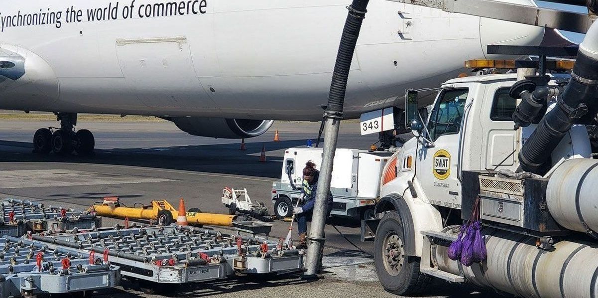A plane is being fueled by a truck at an airport