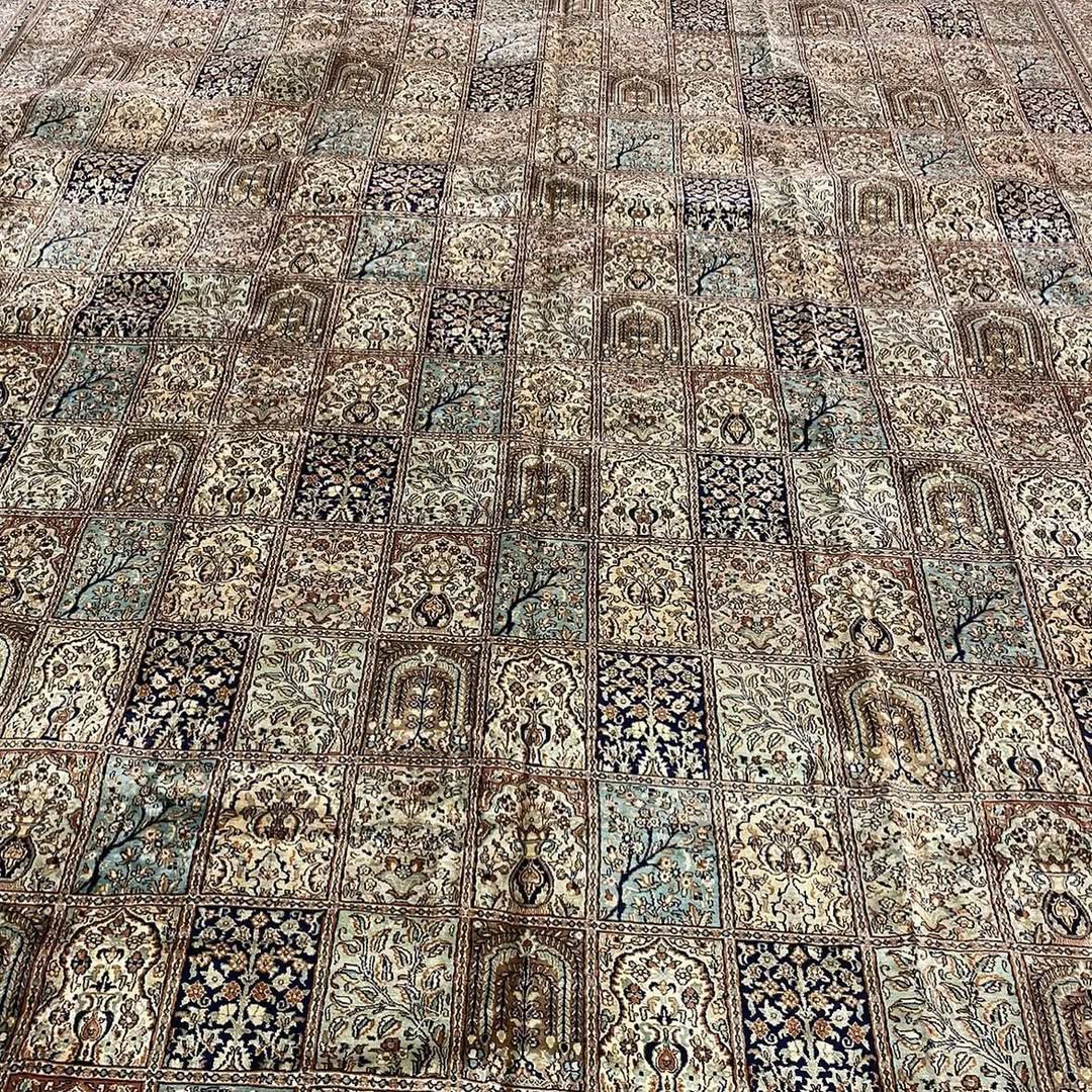 Brown and blue patterned rug with a repeating geometric design.