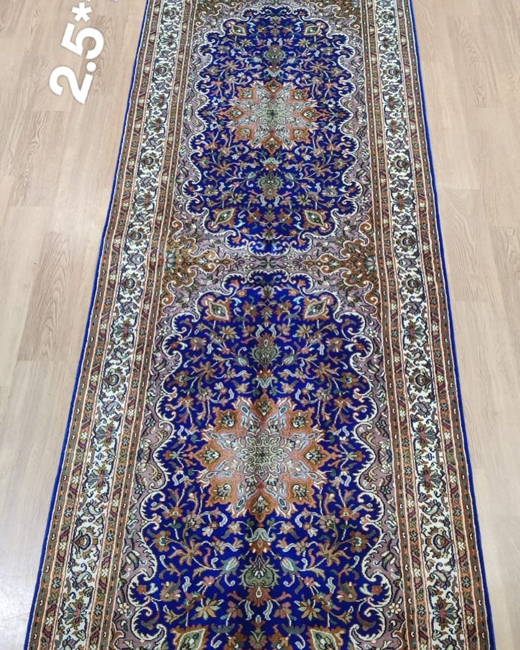 Blue and beige patterned runner rug on a wood floor.