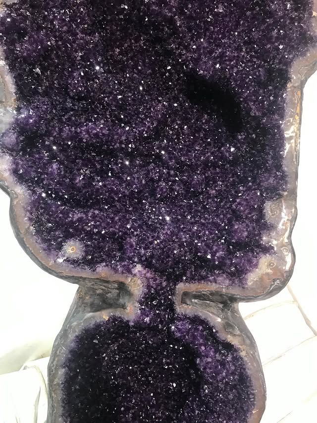 Close-up of a large amethyst geode with dark purple crystalline formations.