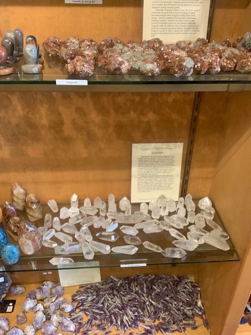 Crystals on display in a store, various shapes and colors including purple, brown and clear.