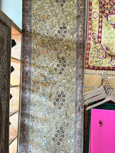 Long, floral runner rug, ivory background with blue and brown flowers, dark border.