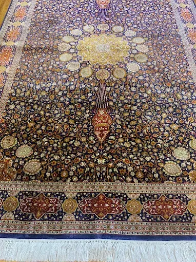 Blue Persian rug with floral design and intricate border.