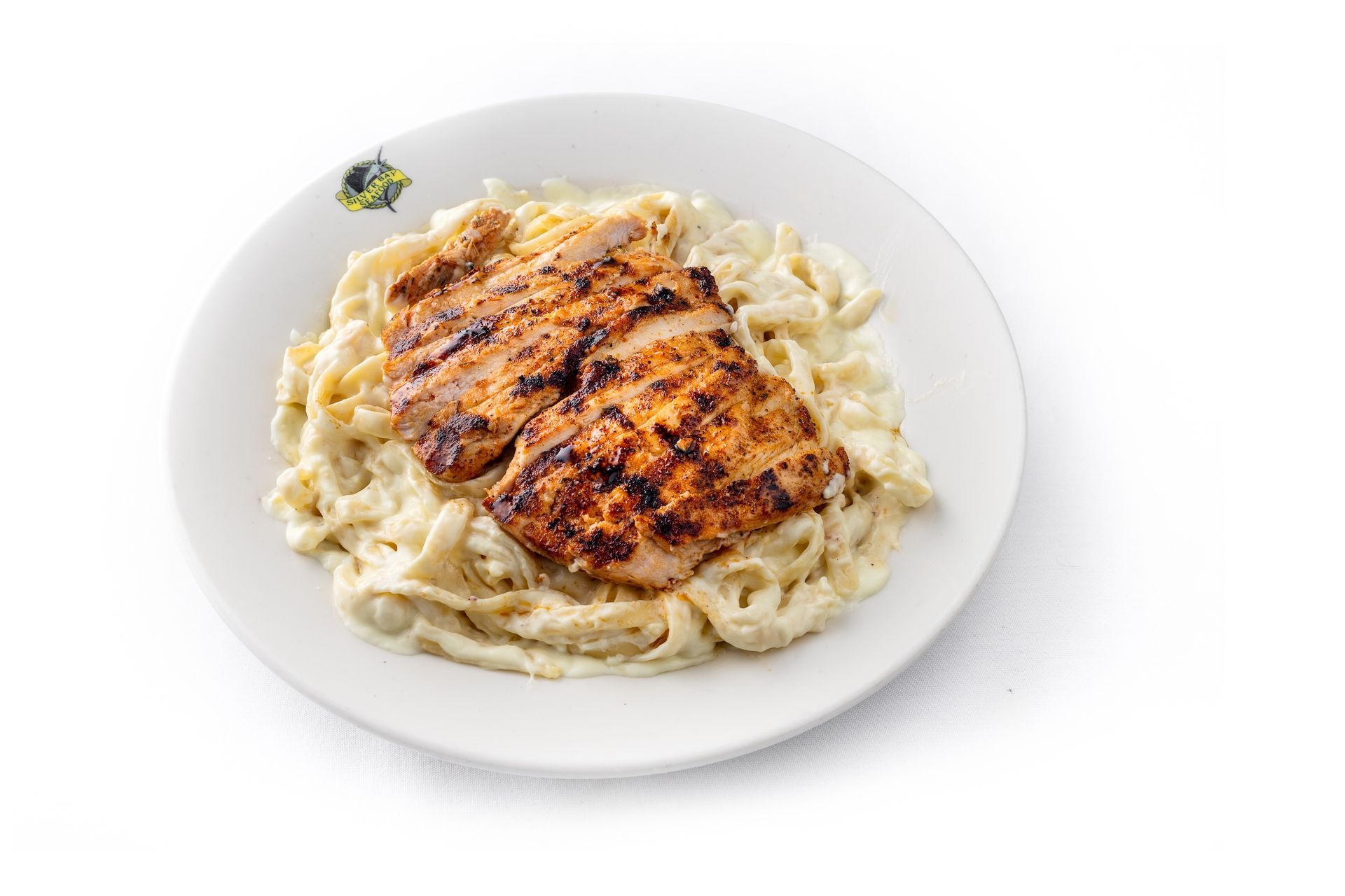 A white plate topped with noodles and chicken on a white background.