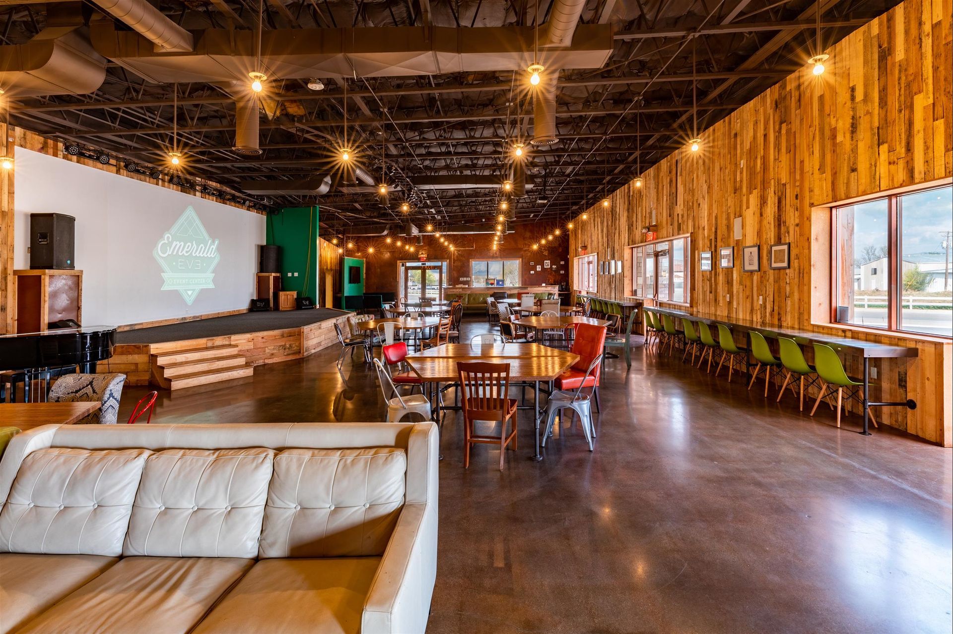 A large room with a couch , tables and chairs.