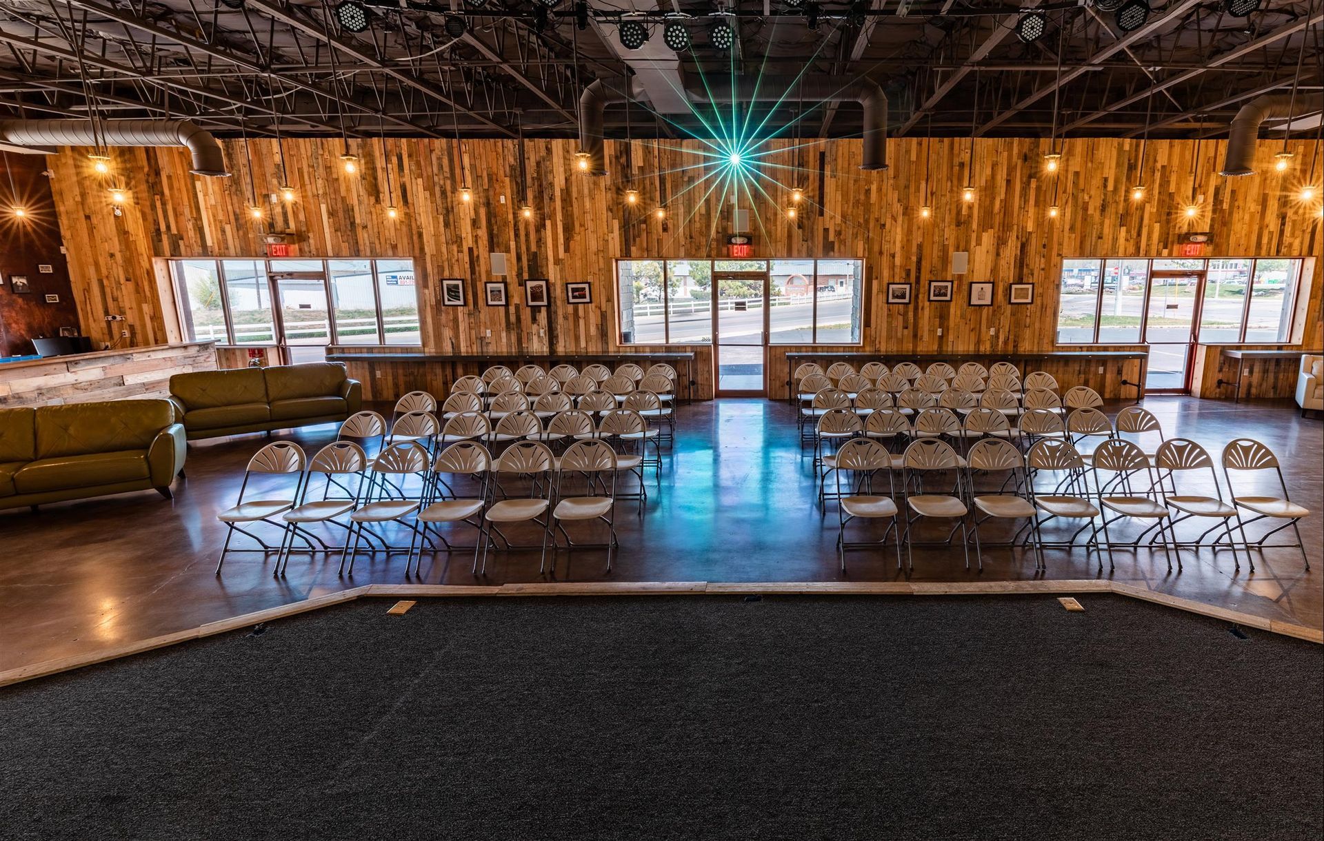 A large room with tables and chairs and a wooden wall.