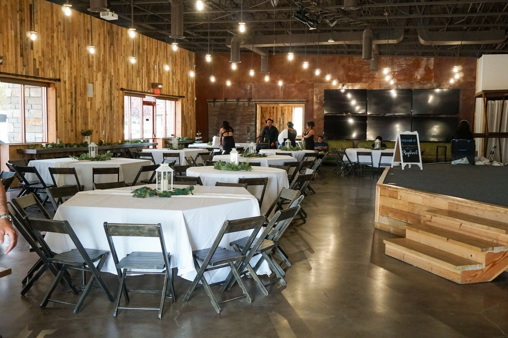A large room with a couch , tables and chairs.