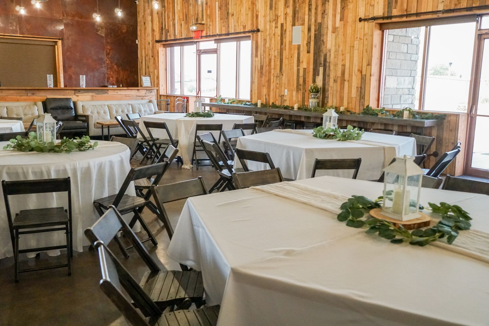 A large room with tables and chairs set up for a wedding reception.