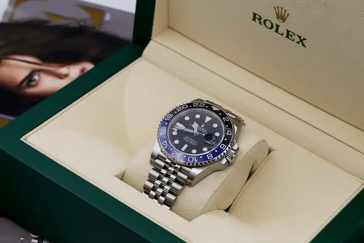 Rolex GMT-Master II watch in a green and beige presentation box.