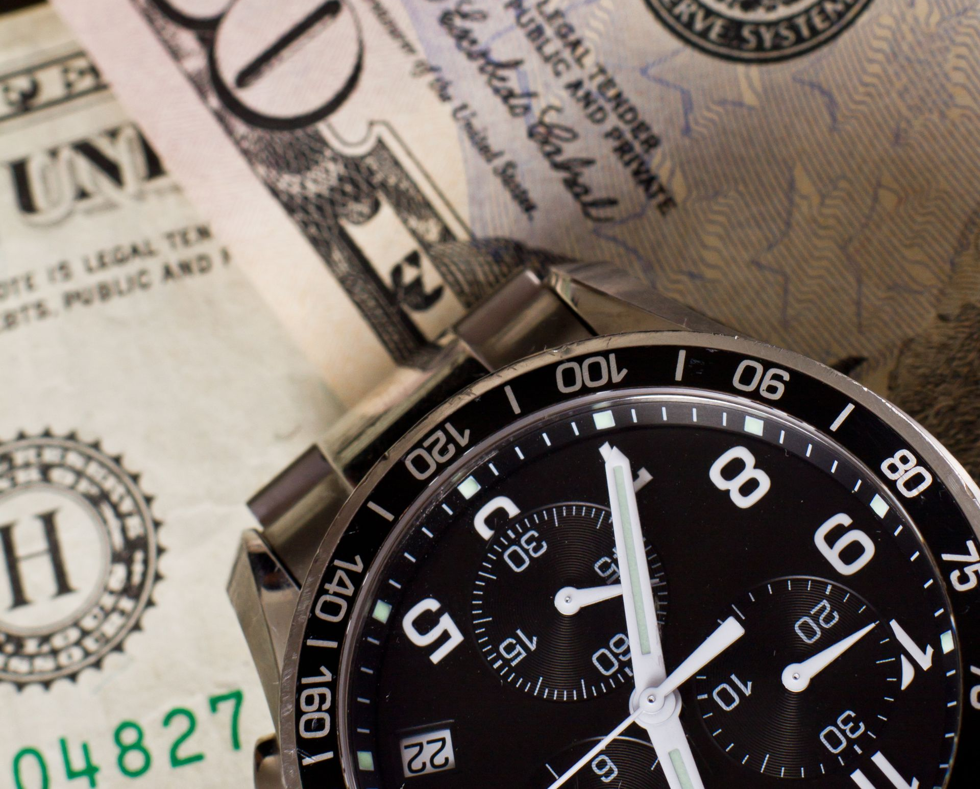 Watch on top of US dollar bills.
