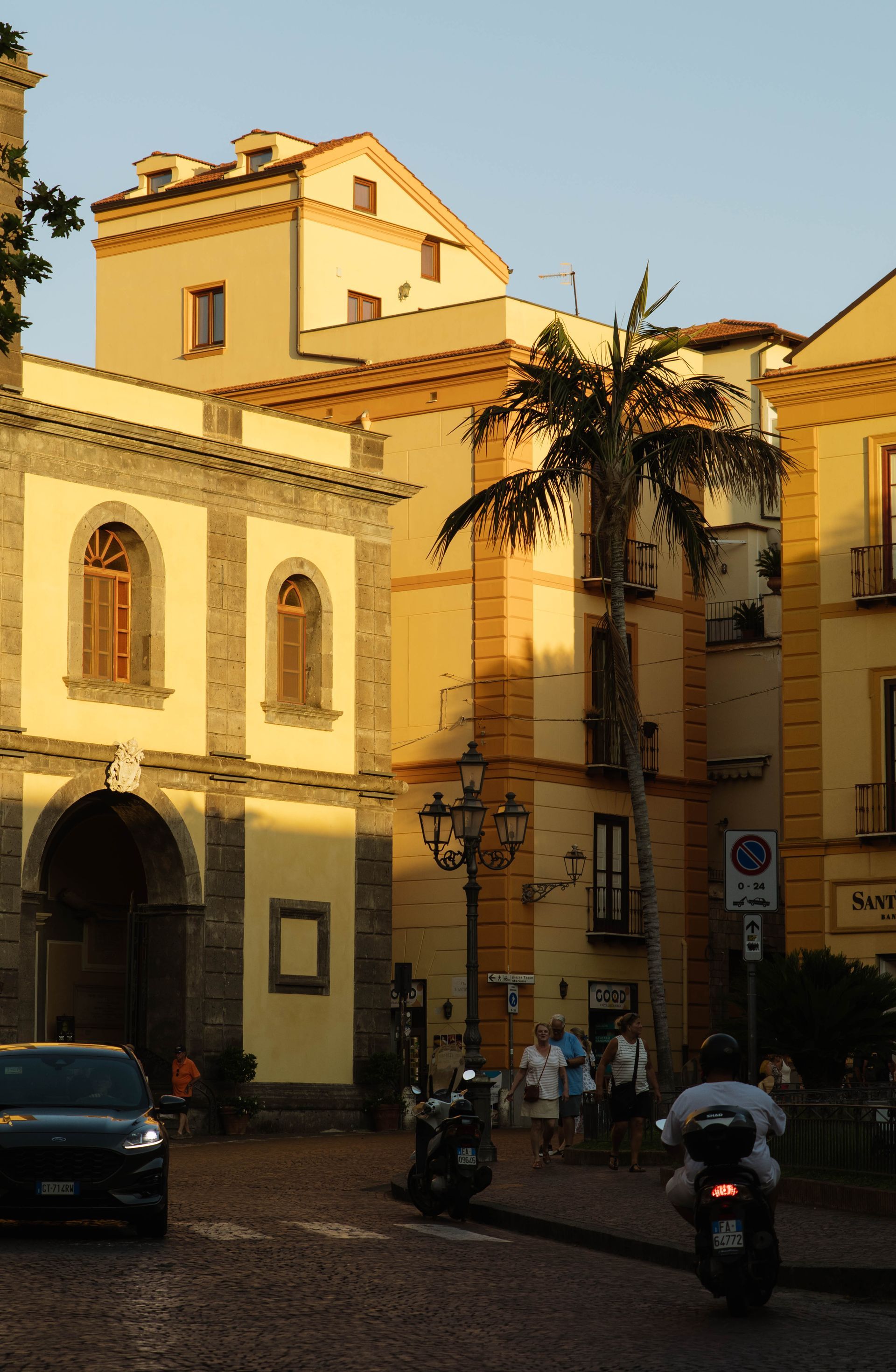 A man riding a motorcycle in front of a building that says no parking