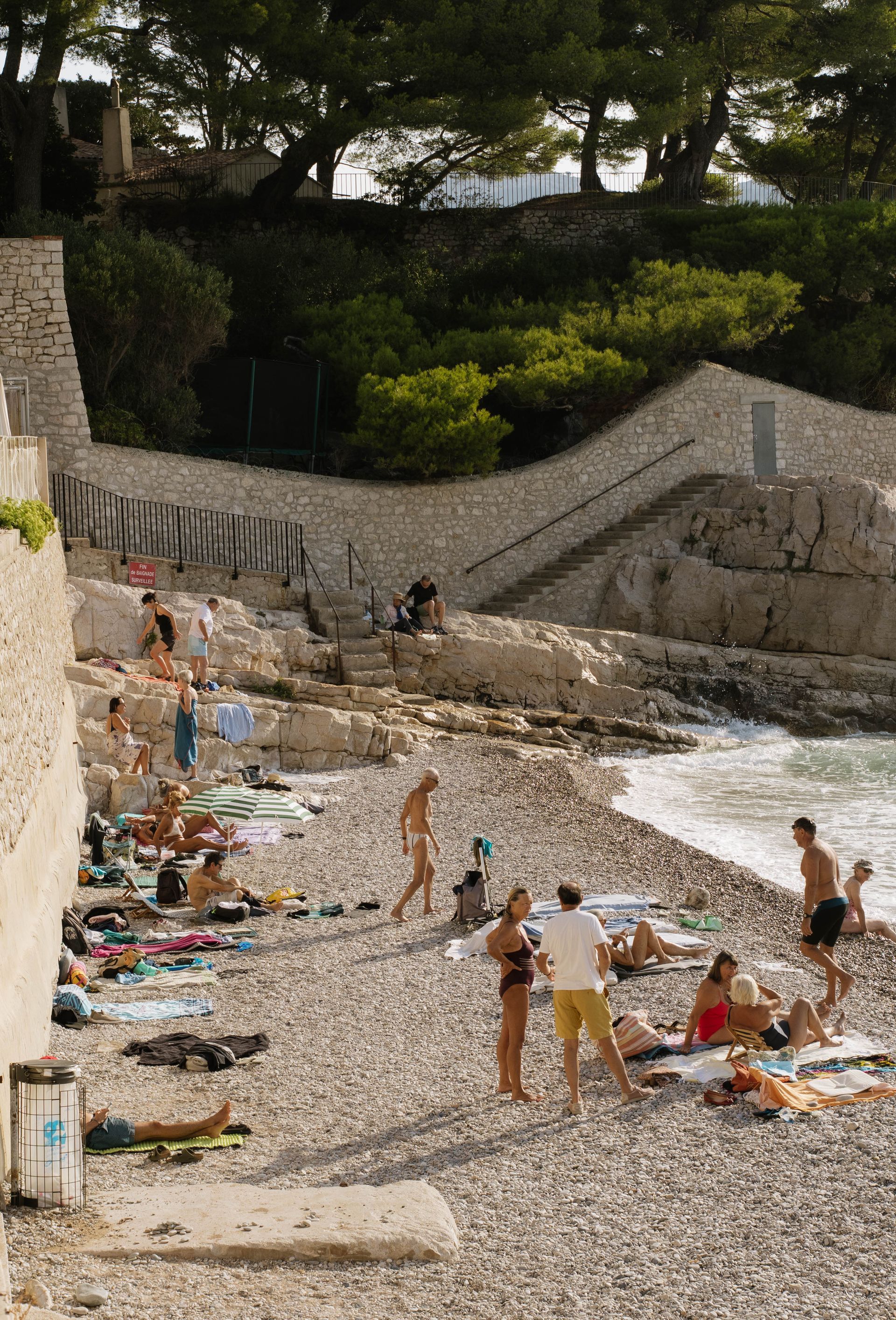 A group of people are sitting on the beach near the water.