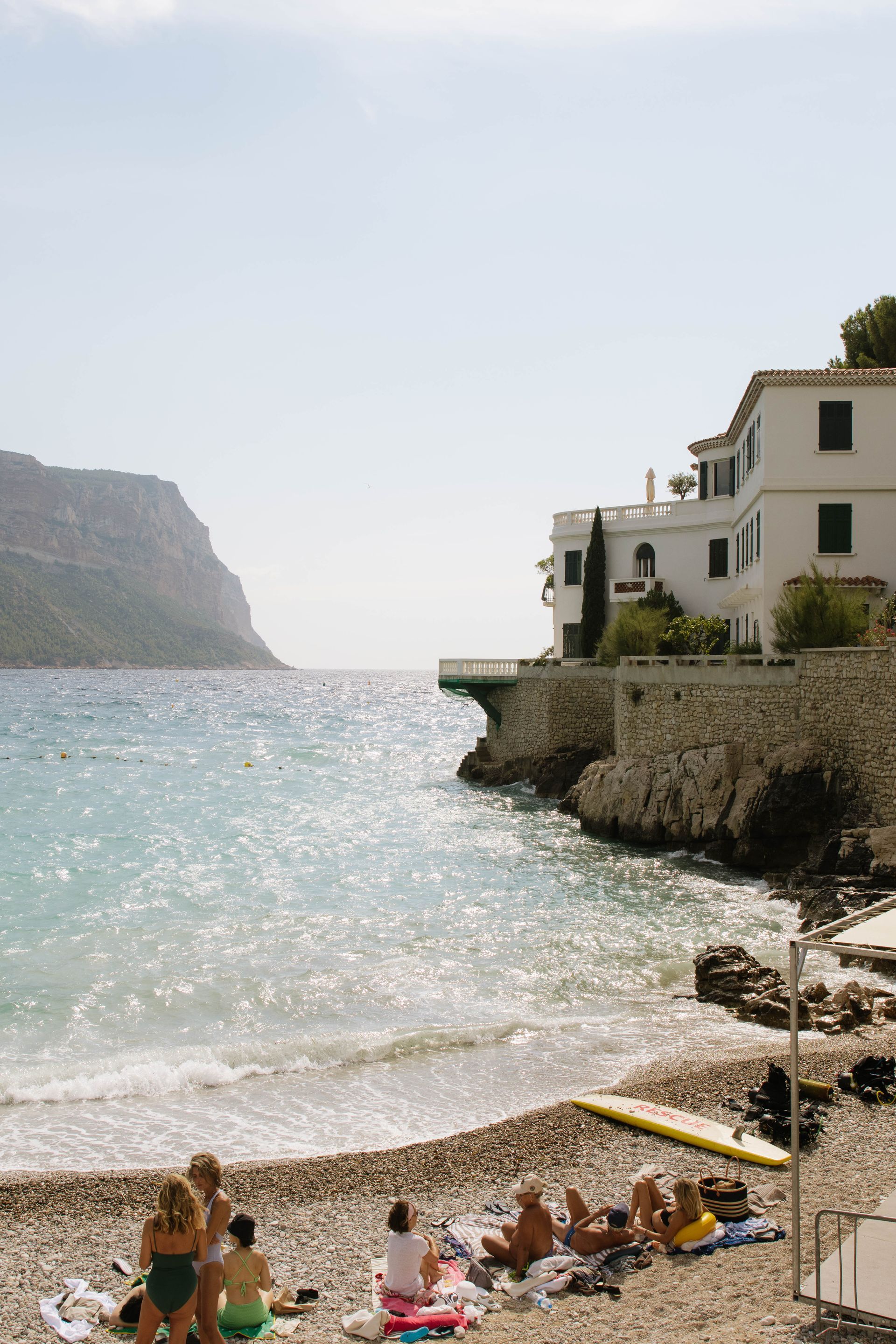 A group of people are sitting on a beach near the ocean.
