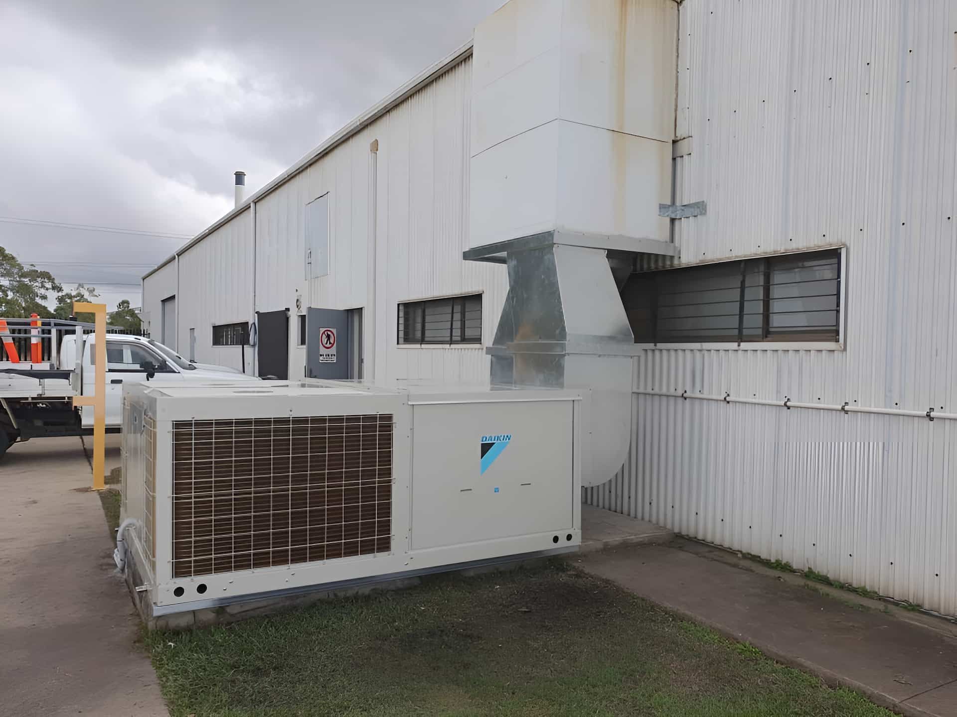 A Large Air Conditioner Is Sitting On The Side Of A Building — Gladstone Sheet Metal Pty Ltd In Gladstone Central, QLD