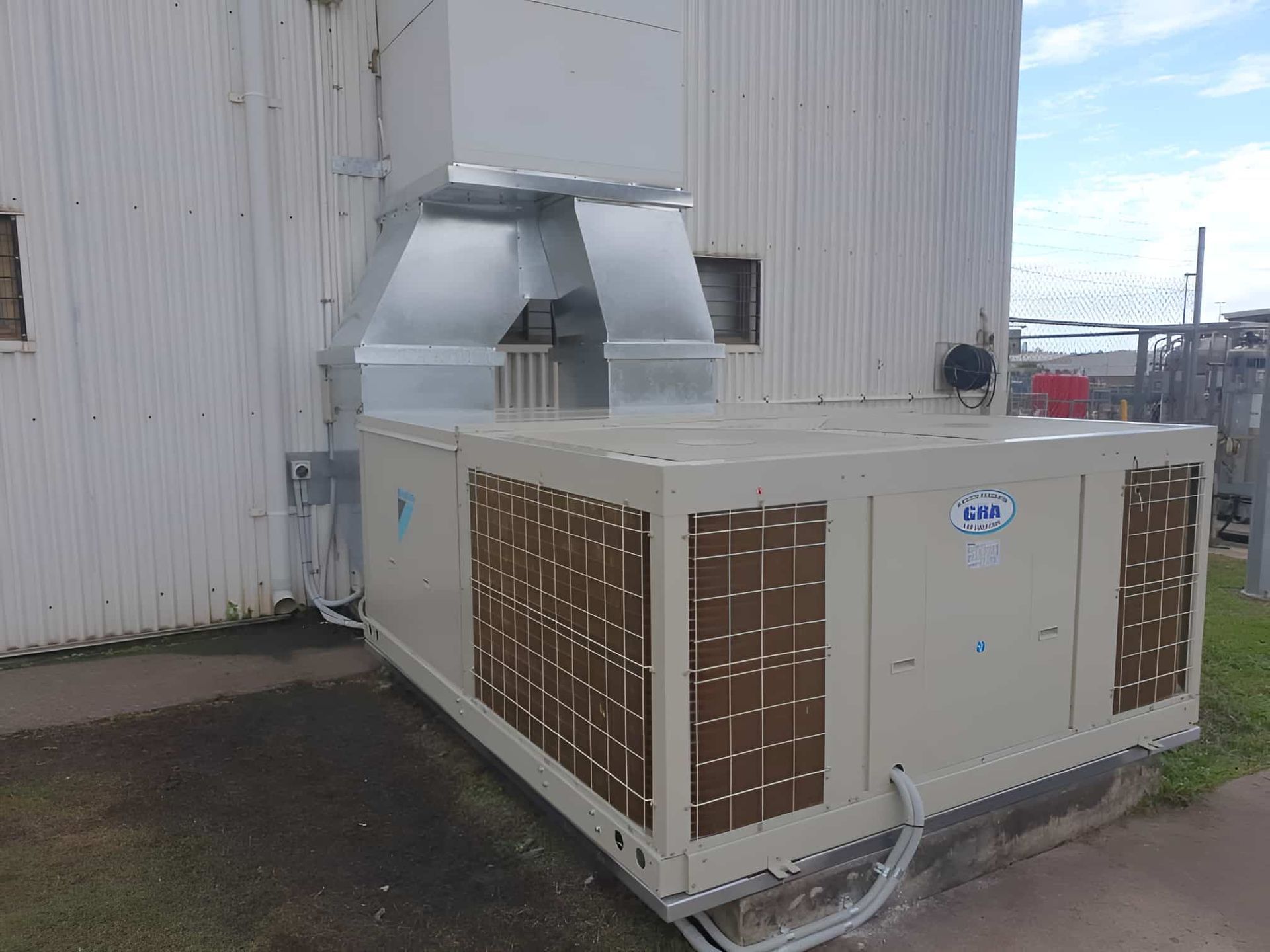 A Large Air Conditioner Is Sitting Outside Of A Building — Gladstone Sheet Metal Pty Ltd In Gladstone Central, QLD
