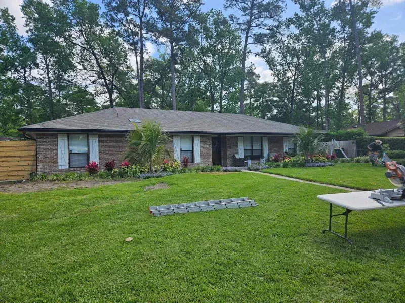 A house with a table in front of it and trees in the background.