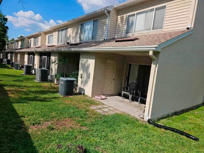 A row of apartment buildings with a lawn in front of them.