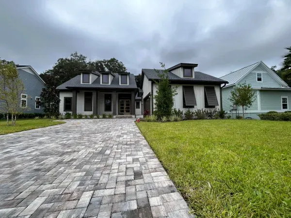 A large house with a brick driveway leading to it