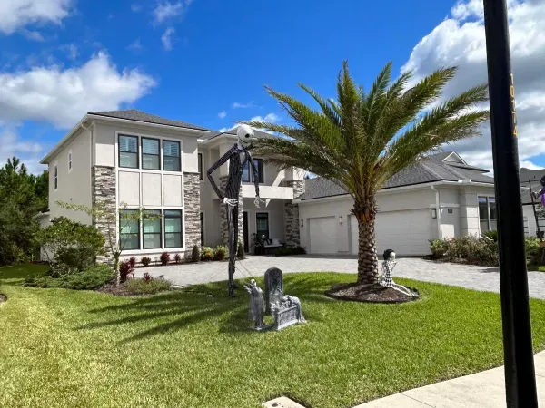 A house with a statue of a skeleton in front of it.