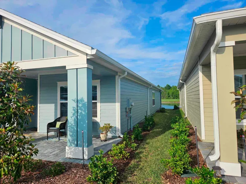 A blue house with a porch and a green house with a porch.