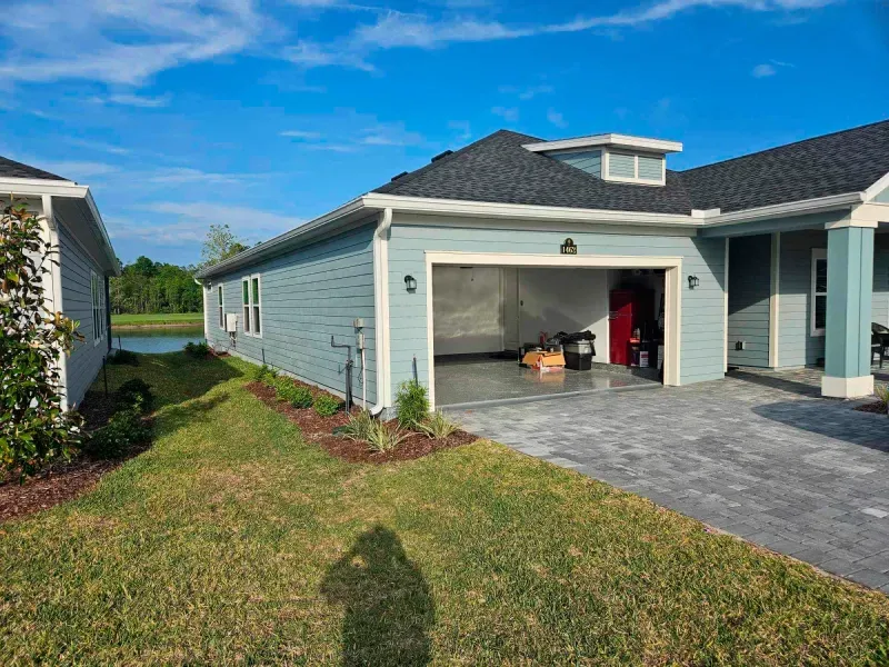 A house with a garage and a driveway in front of it.