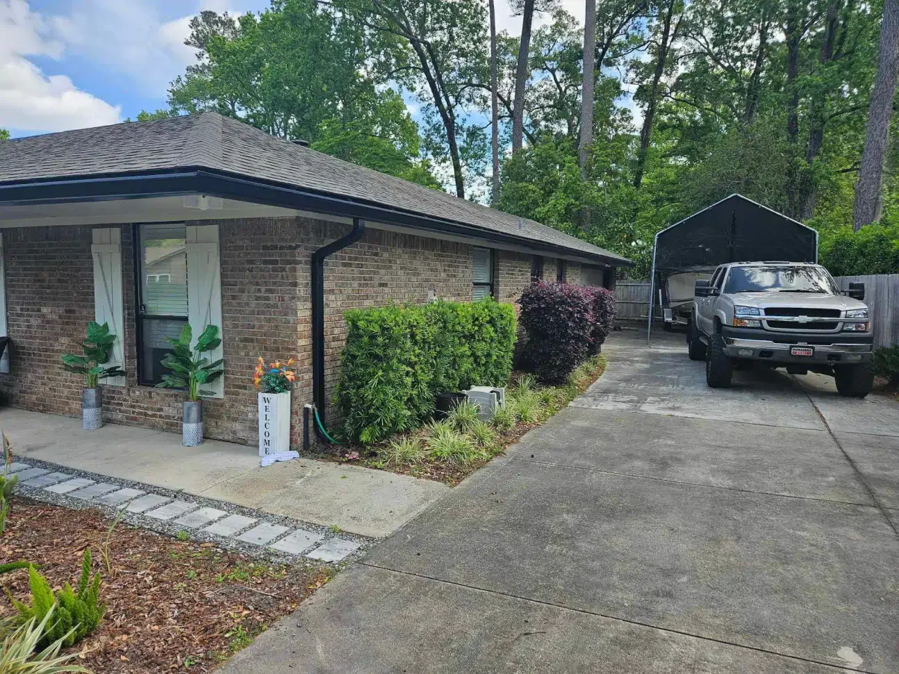 A brick house with a car parked in front of it.