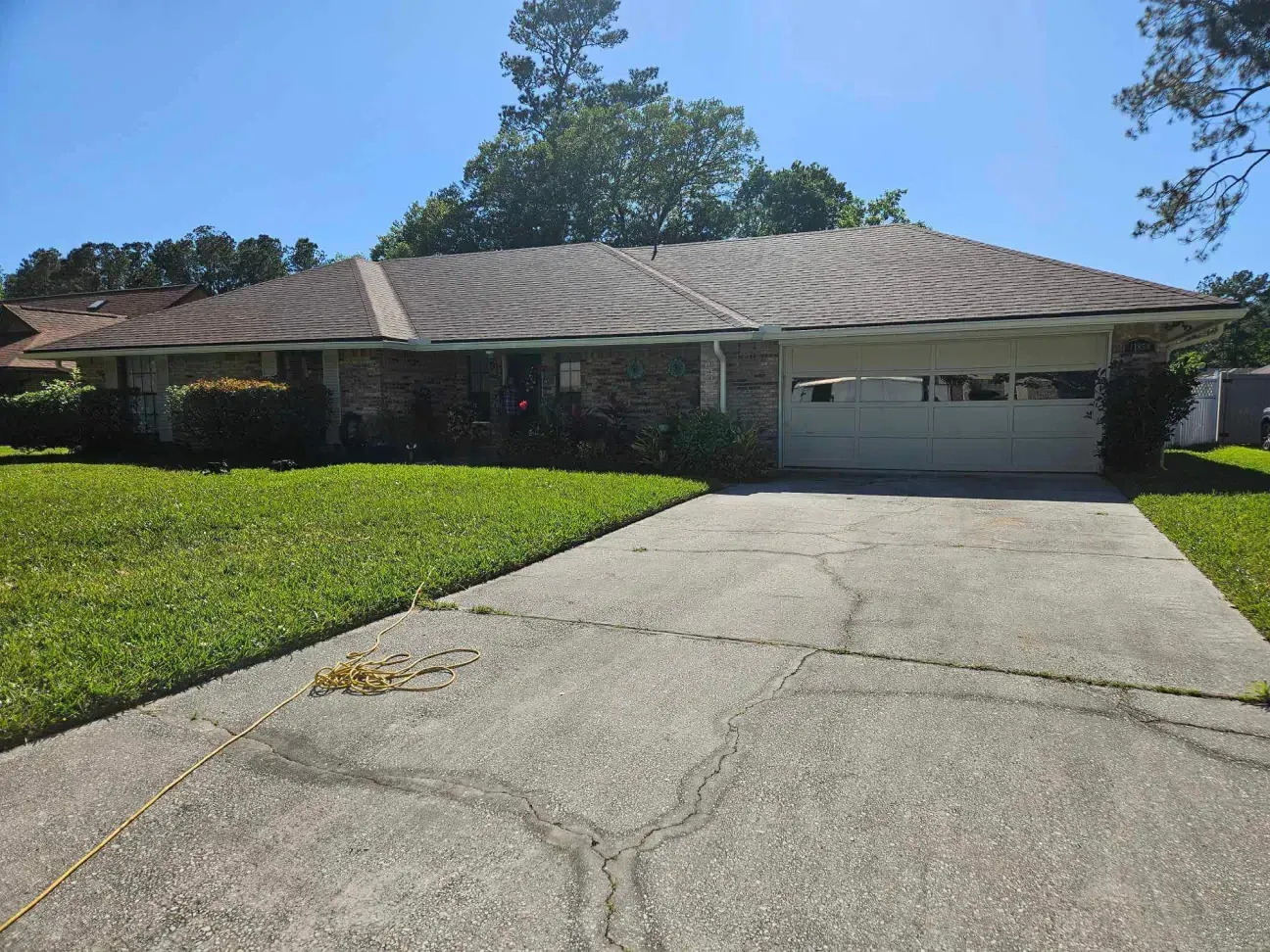 A house with a garage and a driveway in front of it.