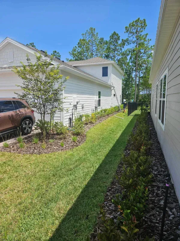 A white house with a brown suv parked in front of it.